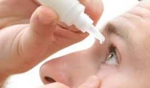 Een vrouw druppelt oogdruppels in haar oog