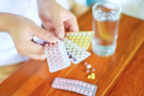 Drie strips anticonceptiepillen met een glas water ernaast