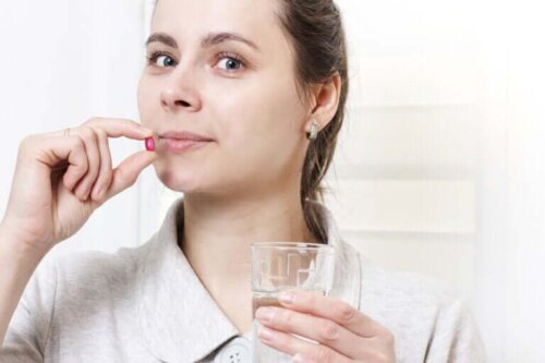 Een vrouw houdt een pil bij haar mond