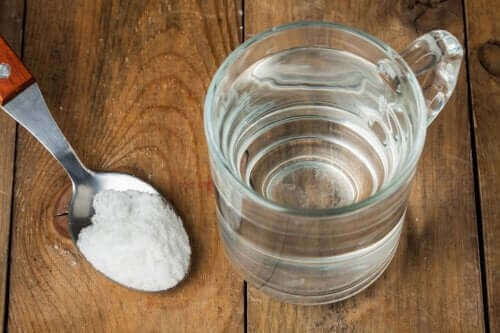 Een glas water en een eetlepel zuiveringszout