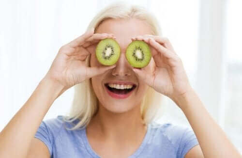 Een vrouw die haar ogen bedekt met kiwi