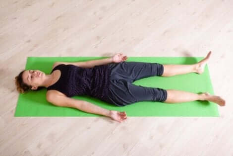 Een vrouw die op een yogamat ligt