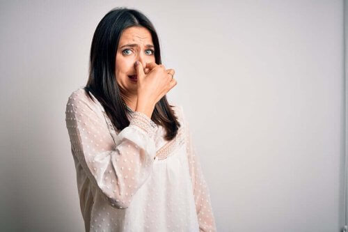 Vrouw houdt neus dicht tegen stank