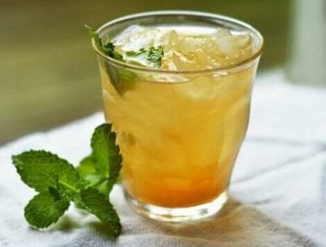 een glas ijsthee van sinaasappel en kaneel