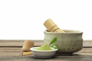 Een kleine kom matcha-poeder naast een grotere kom