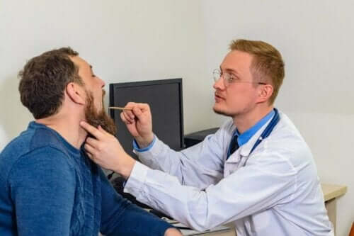 Een man die zijn stembanden laat controleren door een dokter