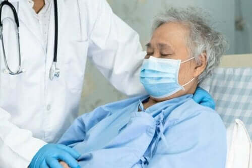 Een patiënt met mondkapje en een arts