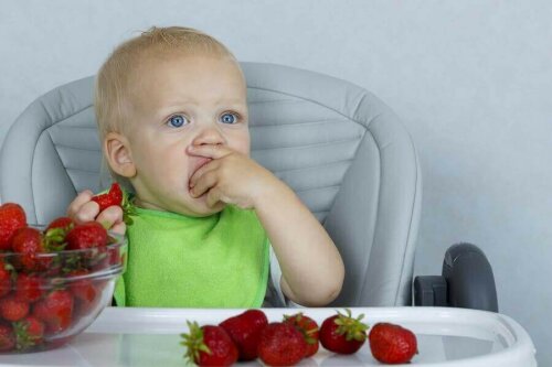 Een kind eet aardbeien