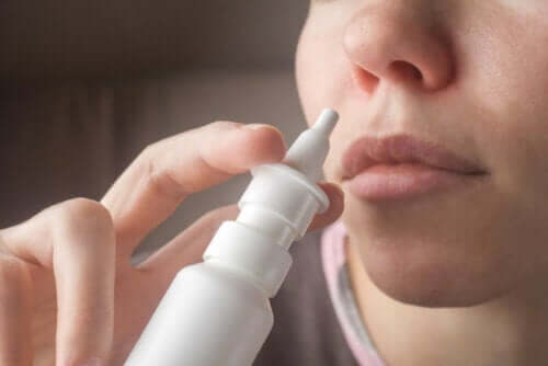 Een vrouw die een neusspray met zoutoplossing gebruikt