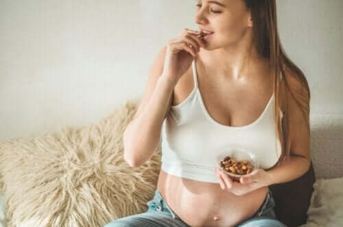Een zwangere vrouw die amandelen eet