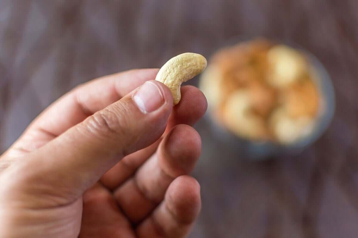 Iemand houdt een cashew vast