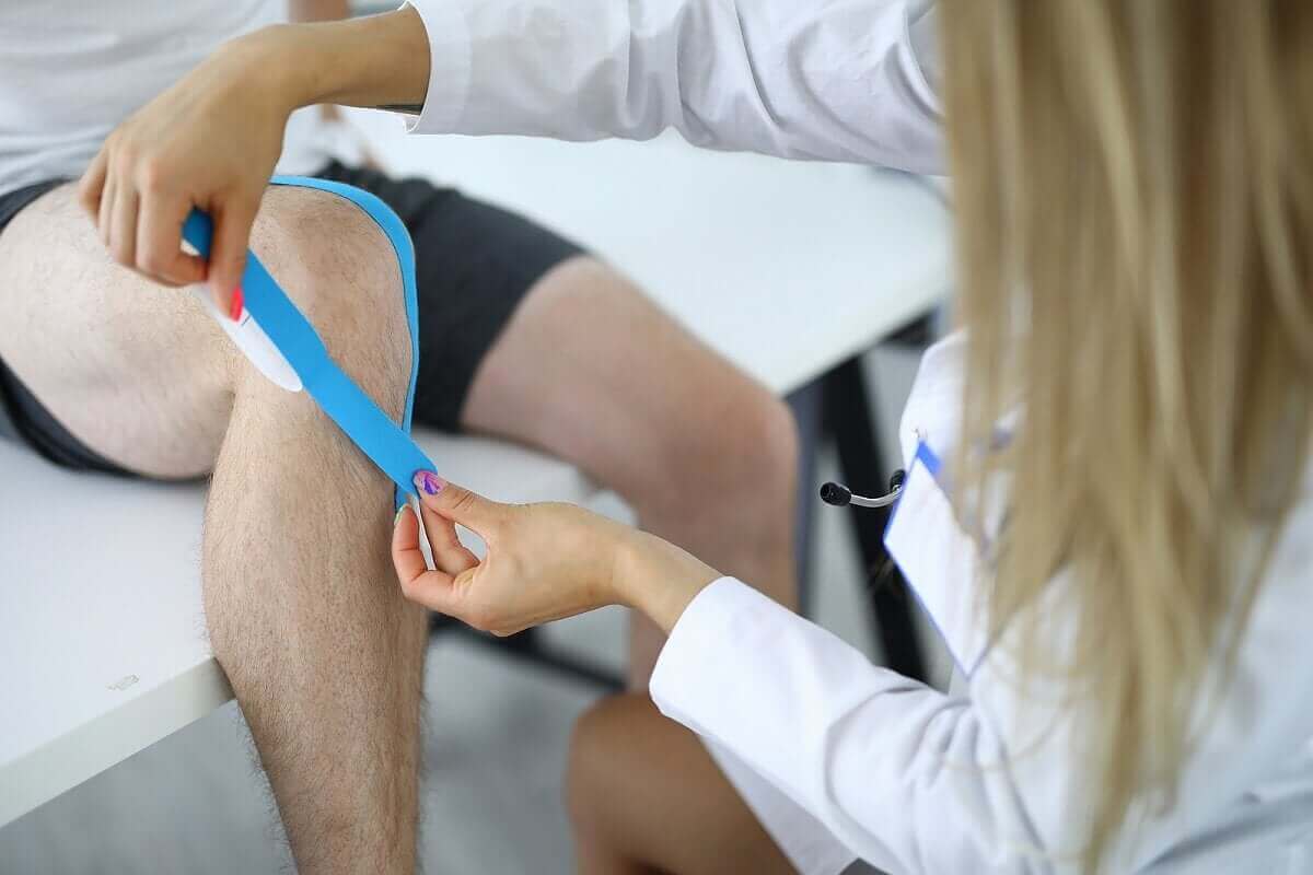 Arts doet tape om knie