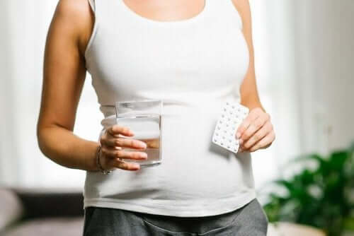 Vrouw met strip pillen en glas water