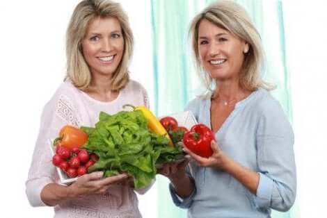Twee vrouwen die groenten vasthouden
