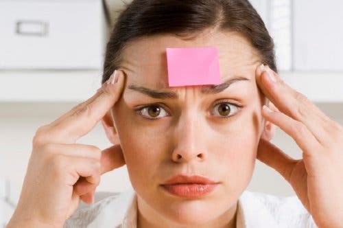 Vrouw met memo op haar voorhoofd