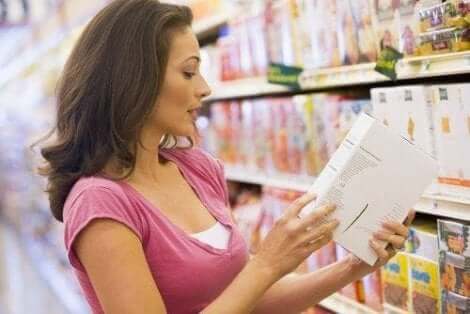 Vrouw leest productingrediënten in de supermarkt