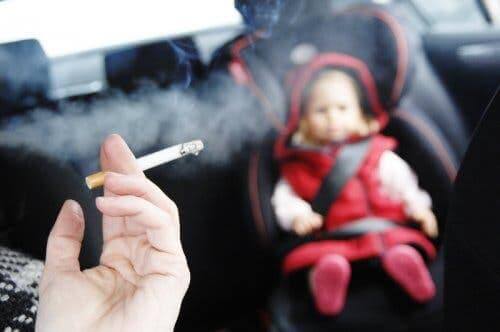 Baby in een auto met iemand die rookt