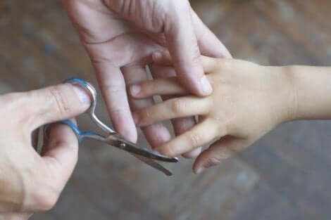 Nagels van een kind worden geknipt