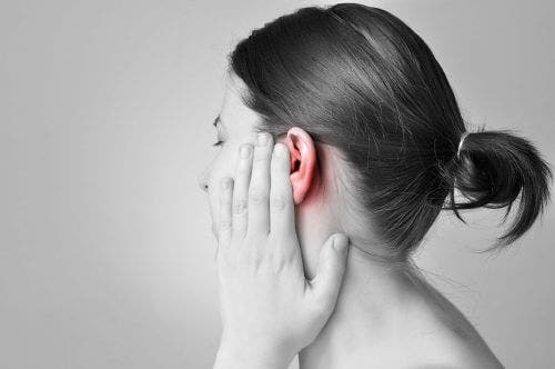 Vrouw met haar hand op pijnlijk oor