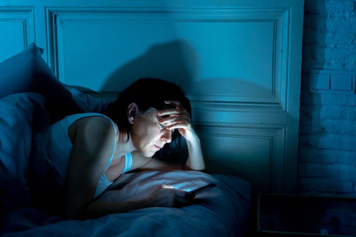 Vrouw zit in de nacht op haar mobiel