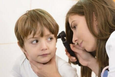 Een arts die de oorontsteking van een kind controleert