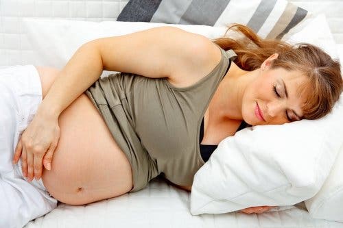 Een zwangere vrouw die ligt te rusten