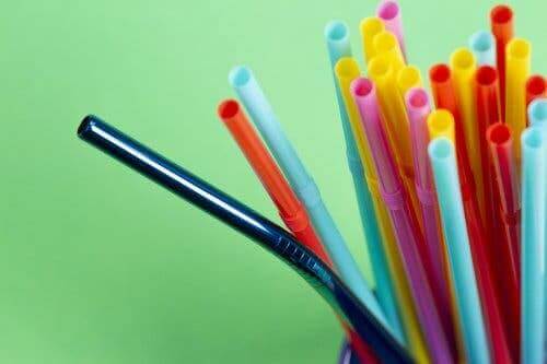 Een metalen rietje tussen plastic rietjes