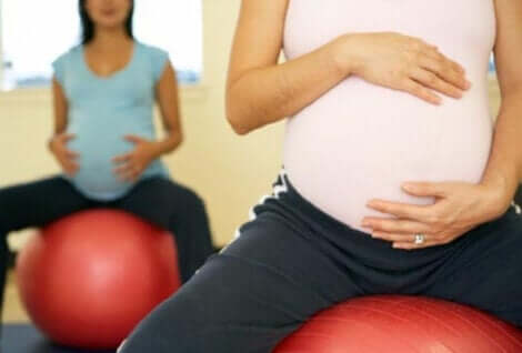 Zwangere vrouwen zitten op een fitnessbal