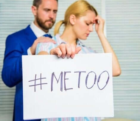 Een vrouw houdt een bord met de hashtag me too omhoog