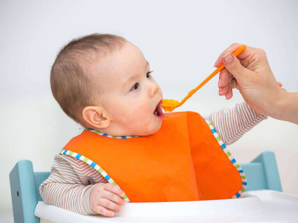Baby eet gepureerde wortel