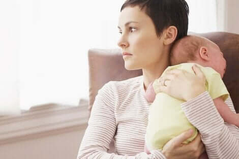 Een bezorgde moeder die haar pasgeboren baby vasthoudt