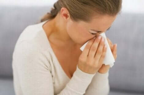 Een vrouw niest door een allergie voor huismijt