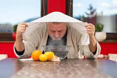 Man met handdoek boven het hoofd die aan het stomen is