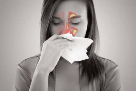Vrouw met sinusitis snuit haar neus