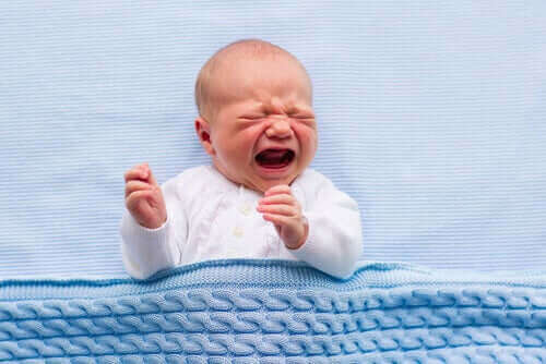 Baby ligt in bed te huilen