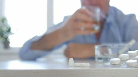 Een man met pillen en alcohol