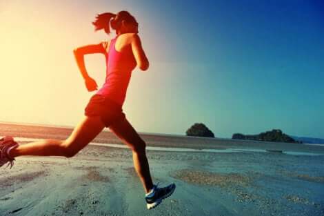 Een vrouw die op het strand hardloopt