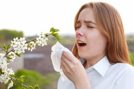 Een vrouw staat naast een plant en niest