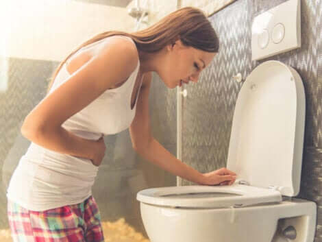 Een vrouw geeft over in de toiletpot