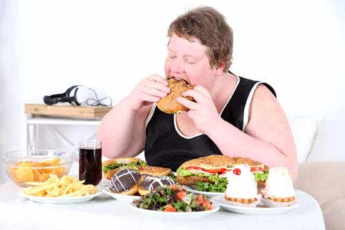 Man die aan een tafel vol eten zit te schransen