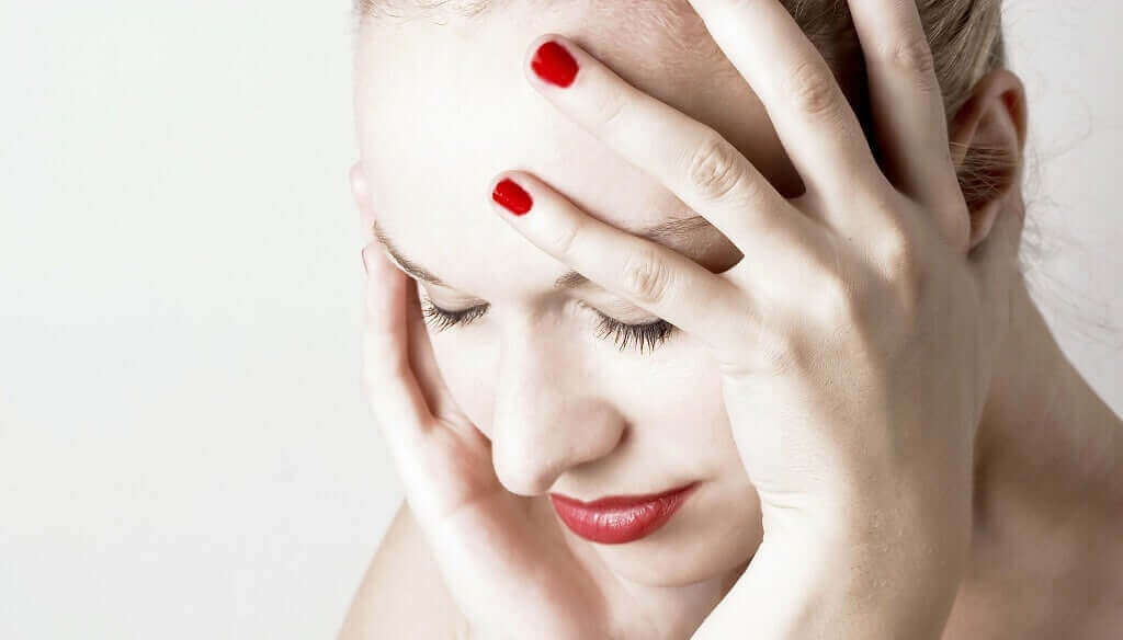 Vrouw houdt haar pijnlijke hoofd vast