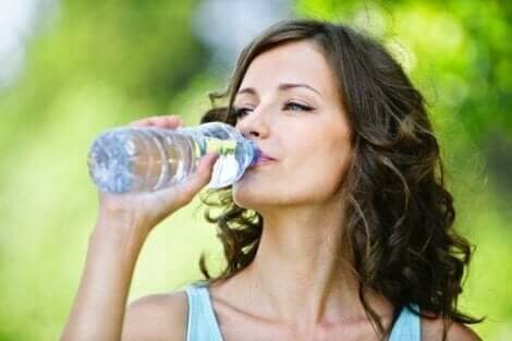 Een vrouw drinkt een flesje water