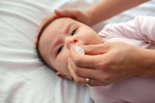 Een baby die een neusspoeling krijgt