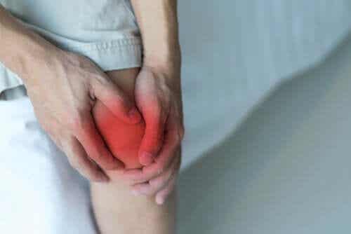 Man houdt pijnlijke knie vast