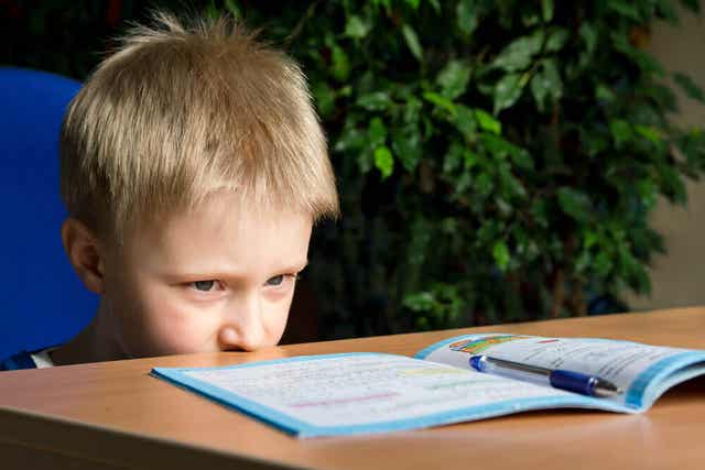 Jongen kijkt tegen zijn schoolwerk op