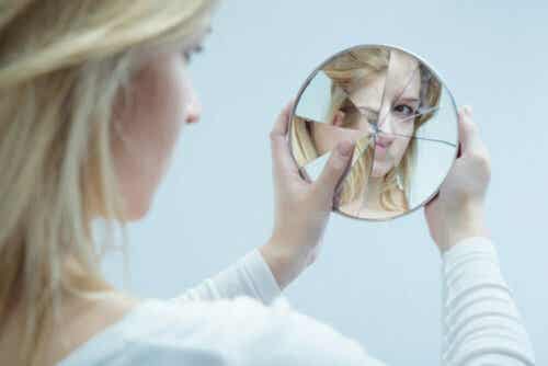 Vrouw kijkt in een kapotte spiegel