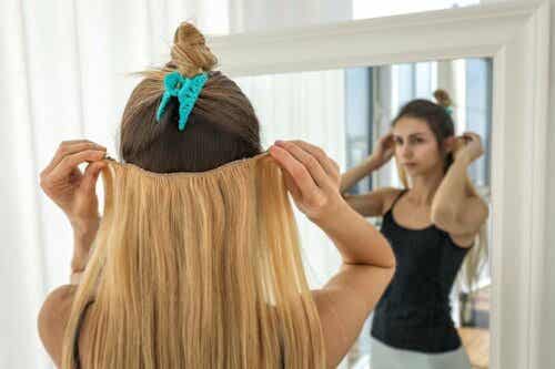 Een vrouw doet haarextensies in haar haar