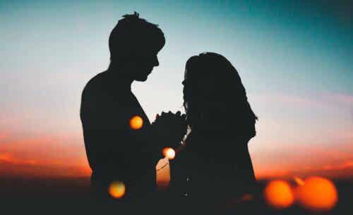 Een man en een vrouw als silhouetten tegen zonsondergang
