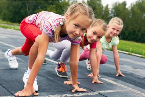 Drie jonge meisjes maken zich klaar voor een hardloopwedstrijdje