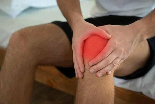Een man die zijn knie vasthoudt